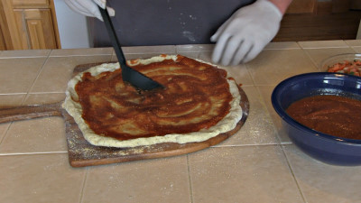 SmokingPit.com - BBQ Chicken & Bacon Pizza recipe wood fire cooked on my Scottsdale Santa Maria style cooker. Applying the sauce.