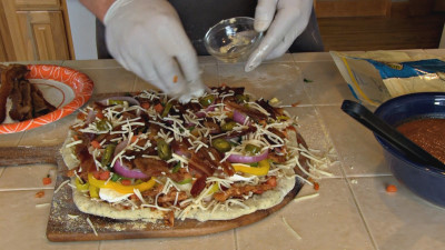 SmokingPit.com - BBQ Chicken & Bacon Pizza recipe wood fire cooked on my Scottsdale Santa Maria style cooker. Adding the garlic.