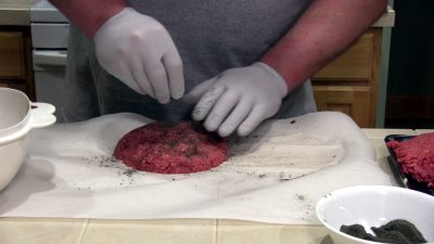 SmokingPit.com - The Colosal Mushroom & Swiss stuffed burger cooked over a oak wood fire on the Scottsdale Santa Maria style pit by Arizona BBQ Outfitters. Seasoning the burgers with Tatonka Dust.