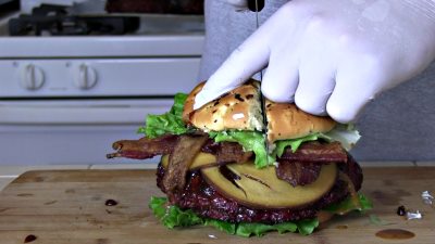 SmokingPit.com - The Colossal Trinity BBQ Surf & Turf burger - stuffed burger cooked over a oak wood fire on the Yoder YS640 Pellet cooker.- Slicing the burger.