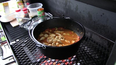 SmokingPit.com - Dutch oven Arroz Con Pollo cooked in a Lodge 12" dutch oven in my Scottsdale Santa Maria style cooker. Adding the browned chicken back in.