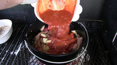 SmokingPit.com - Dutch oven Swiss Steak cooked in a Lodge 12" dutch oven in my Scottsdale Santa Maria style cooker. Adding the tomatoes.