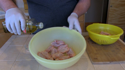 SmokingPit.com - Mad Hunky Tiger Sauce Hot Wings.  Slow cooked on the yoder YS640. Oiling the wings.