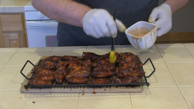 SmokingPit.com - Mad Hunky Tiger Sauce Hot Wings.  Slow cooked on the yoder YS640. Applying Tiger Sauce to the wings.