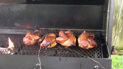 SmokingPit.com - Super moist Orange Chicken with Garlic Red Potatoes cooked on a Scottsdale Santa Maria style cooker over an Oak wood fire. The Scottsdale by Arizona BBQ Outfitters. - Cooking the chicken.