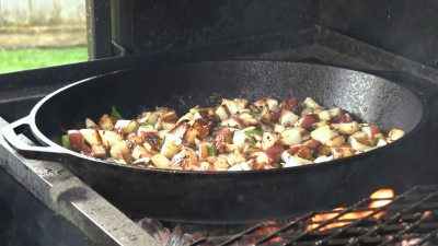 SmokingPit.com - Super moist Orange Chicken with Garlic Red Potatoes cooked on a Scottsdale Santa Maria style cooker over an Oak wood fire. The Scottsdale by Arizona BBQ Outfitters. - Garlic Red Poatatoes in the Lodge cast iron skillet.