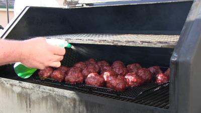 SmokingPit.com BBQ - Signature Apple Smoked Meatball Sub with a fresh tangy marinara. Misting the meatballs.