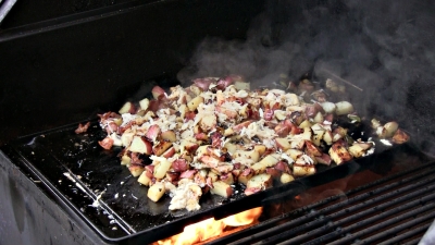 SmokingPit.com - Dungeness crab meat, bacon, garlic, green onion, gree pepper and postatoes fried with Creole seasoning. Cooking on the griddle.